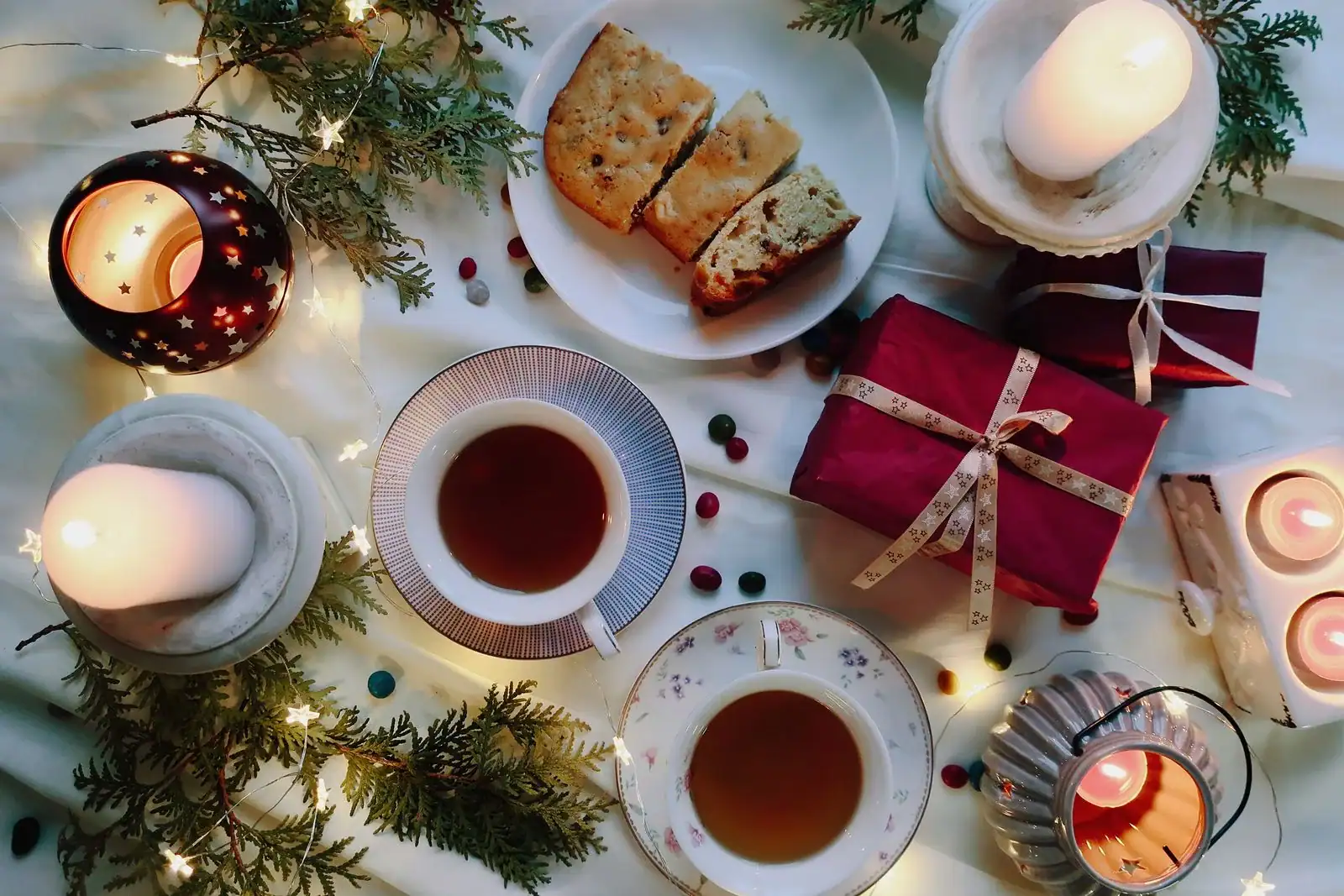 A holiday tea table with cake, candles and a wrapped gift