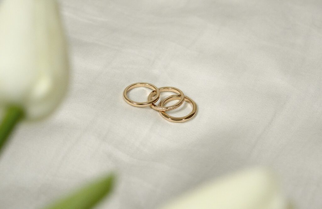 Three stacked gold rings resting on white linen