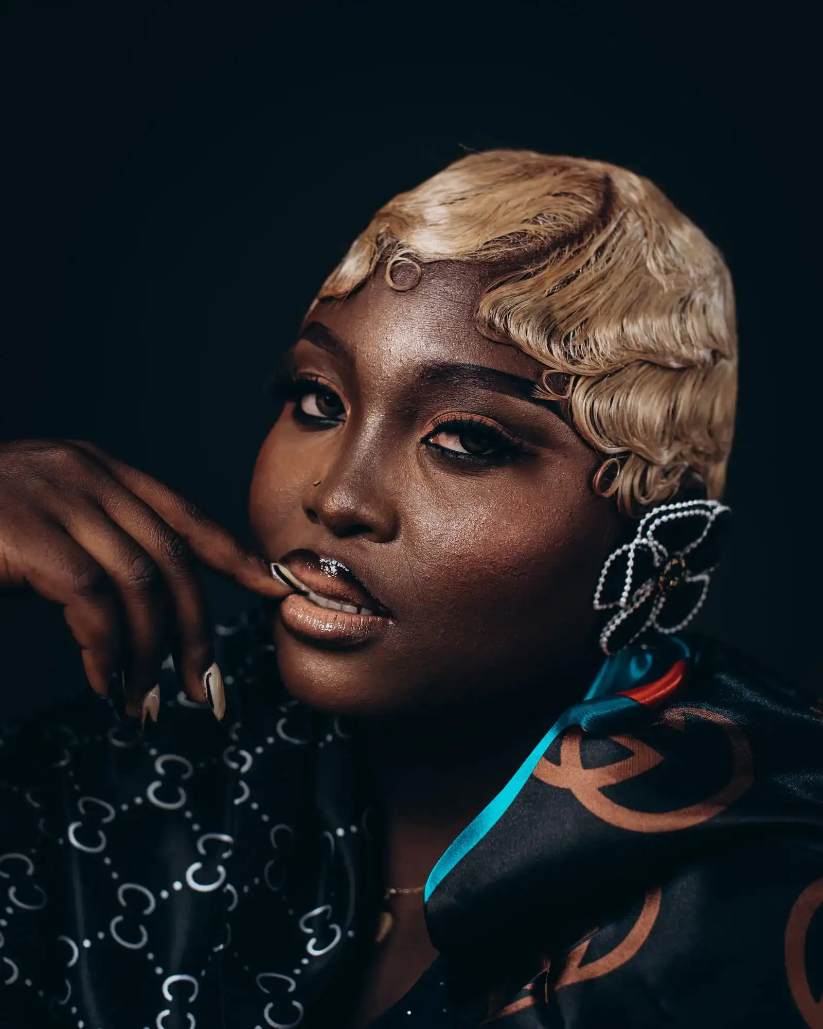 A woman with sculpted blonde finger waves and a dramatic earring